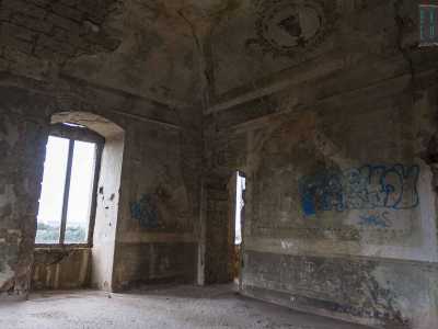 Una scritta tracciata con una bomboletta spray blu in particolare deturpa una parte di muro che un tempo ospitava un dipinto